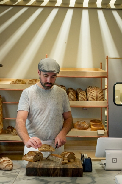 Mathieu Choux, owner of Gaston’s Bakery in Boise, slicing bread.